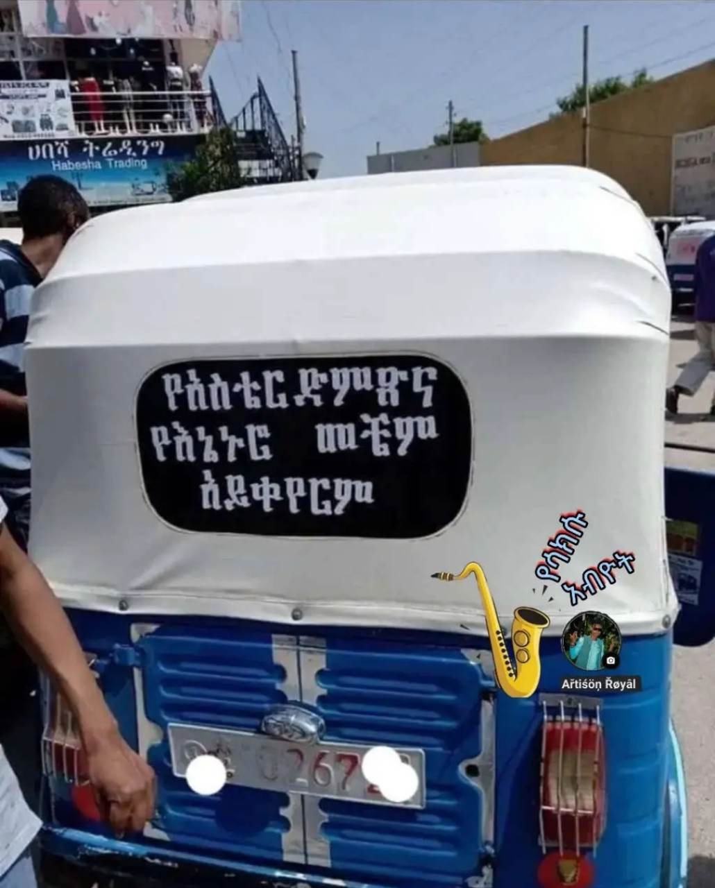 a man is putting a sign on the back of a blue truck